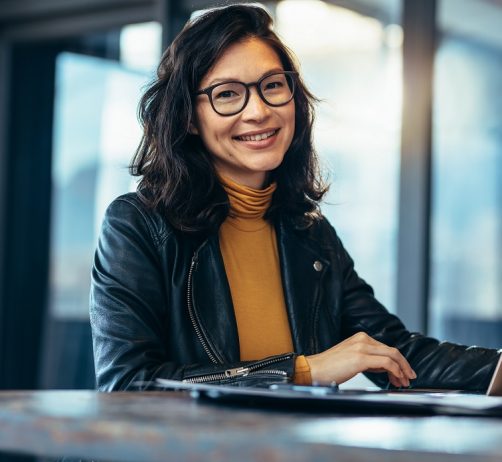 Portrait,Of,Attractive,Business,Woman,Sitting,At,Her,Desk,With