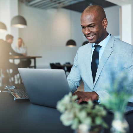 Young,African,American,Businessman,Smiling,While,Sitting,At,His,Desk